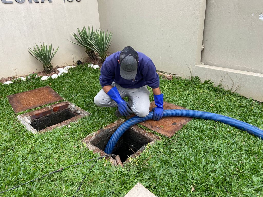 Equipe de profissionais realizando serviço de desentupimento de esgoto em desentupidora Campeche