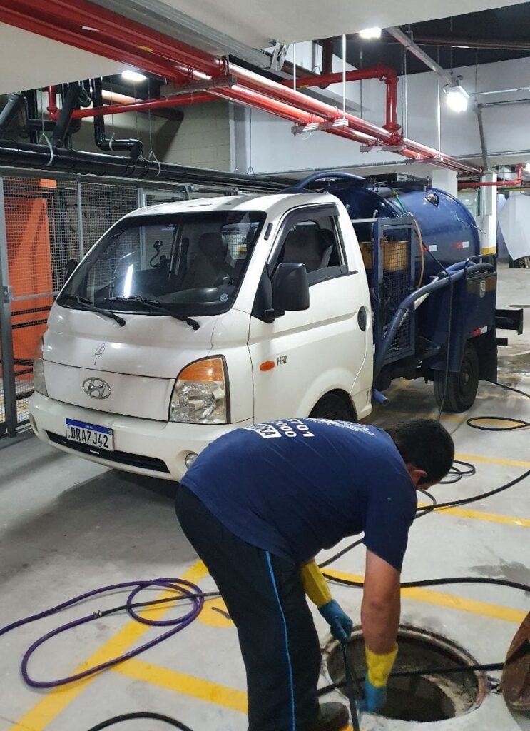 Equipe de profissionais realizando serviço de desentupimento de esgoto em desentupidora e limpa fossa Campeche